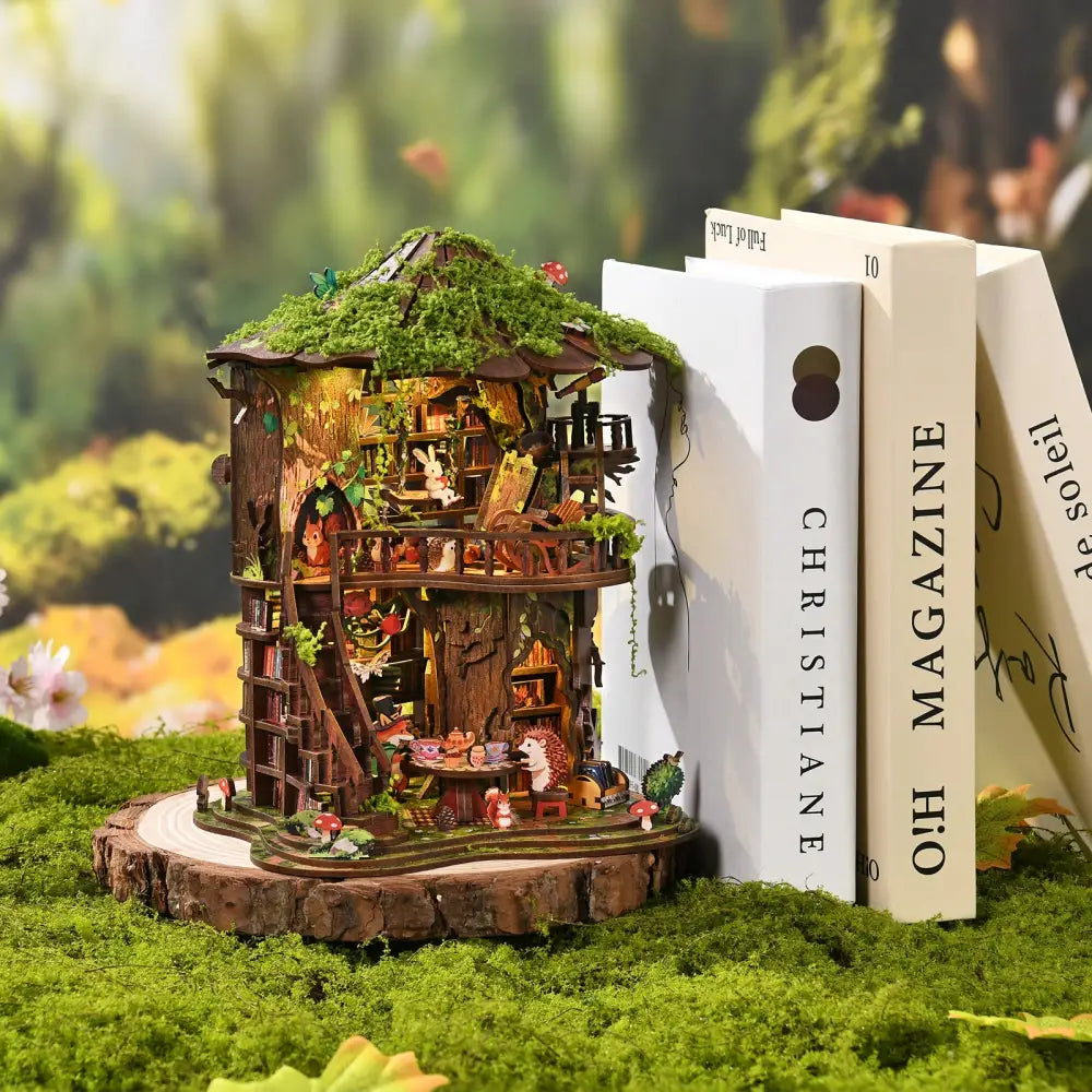 A detailed wooden treehouse miniature with moss roof and mini figurines from the forest tea book club kit with led lighting