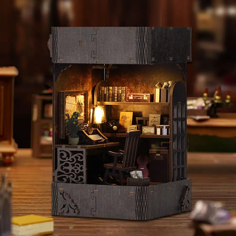 Miniature detective agency book nook kit with dark gray wooden desk lamp and warm glowing light on ornate metal base