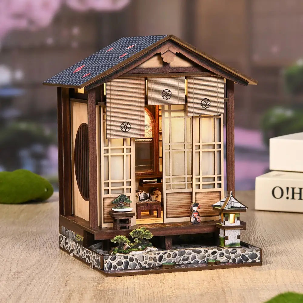 Miniature japanese-style wooden house with dark blue tiled roof and shoji doors in moss-lantern harmony with led light australia
