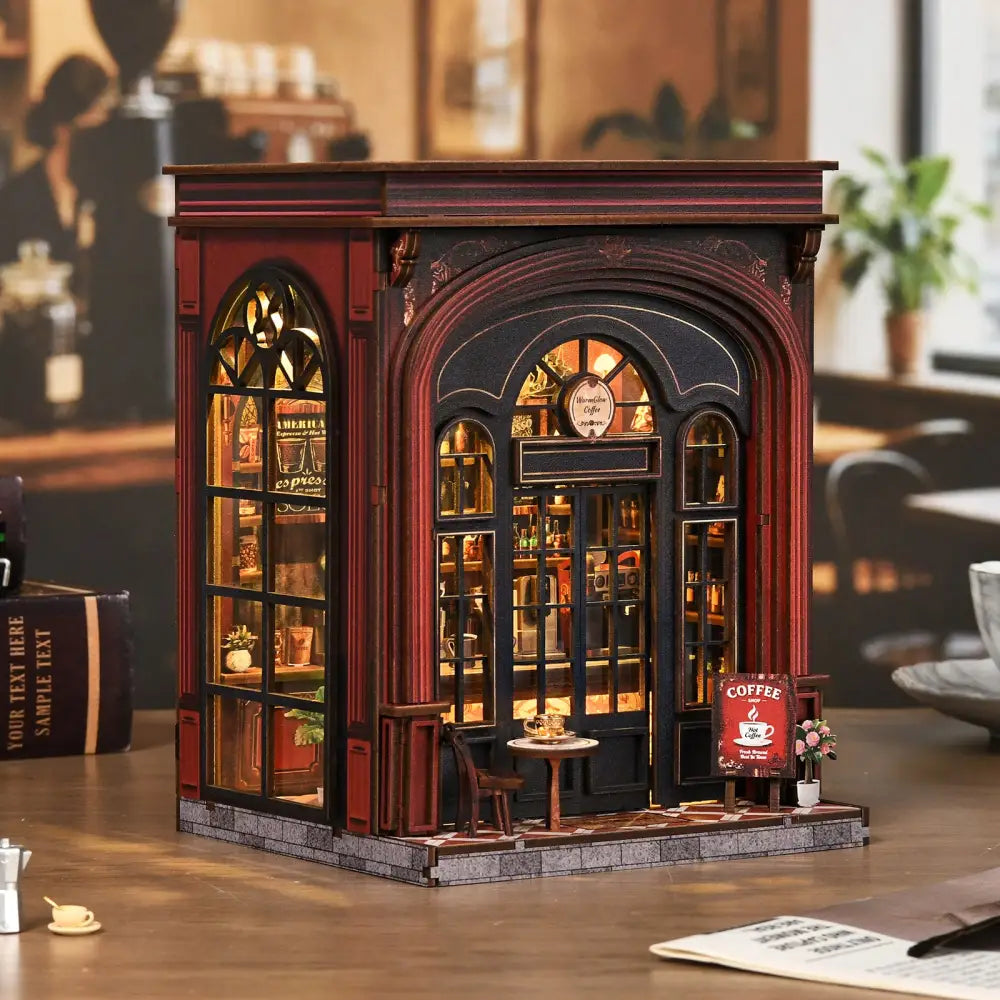 A miniature red and black warmglow coffee diy book nook with detailed windows shelves and a coffee sign outside