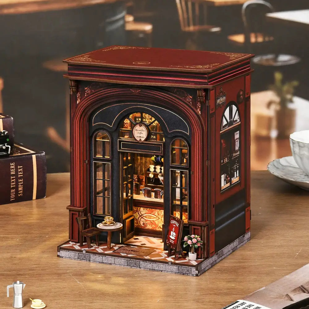 A warmglow coffee diy book nook features a detailed coffee shop diorama with red black panels and warm lighting