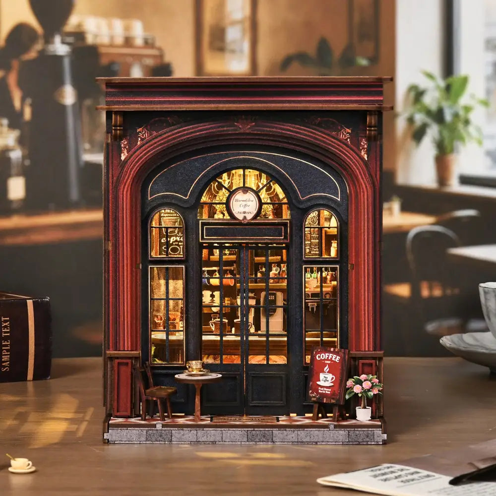 A miniature wooden warmglow coffee diy book nook with dark red facade and glowing arched windows showing tiny shelves