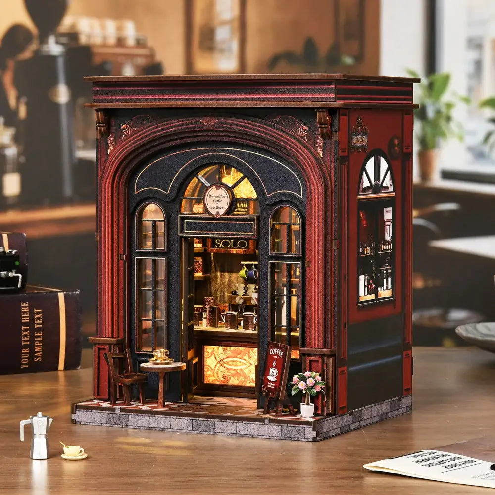 A warmglow coffee diy book nook featuring a red and black miniature coffee shop with detailed lit interior and decor